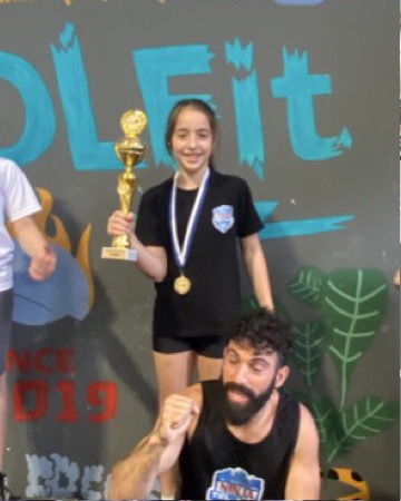 הבת של עמית עם גביע ומדליה על הפודיום