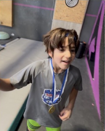 הבן הצעיר של עמית מחייך עם מדליה