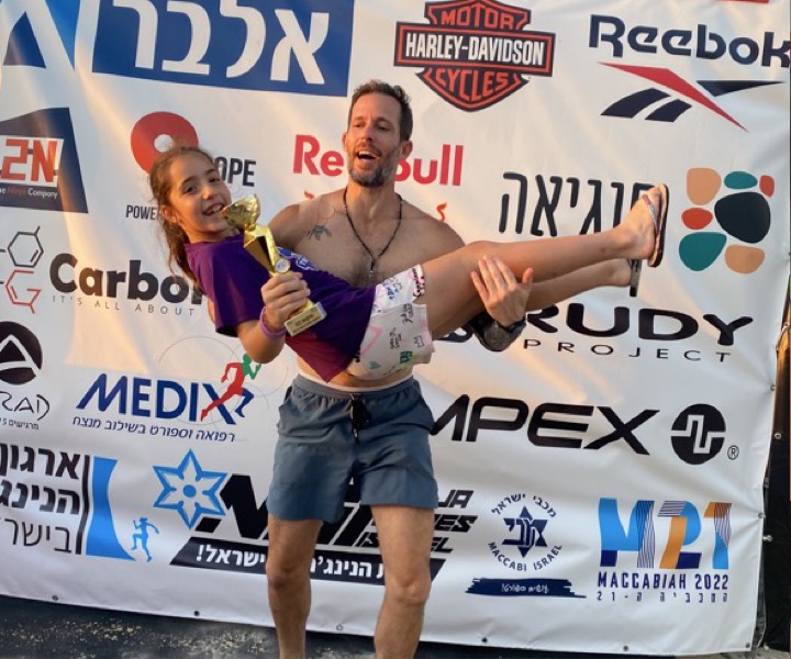 עמית מרים את בתו עם הגביע אחרי תחרות נינג'ה